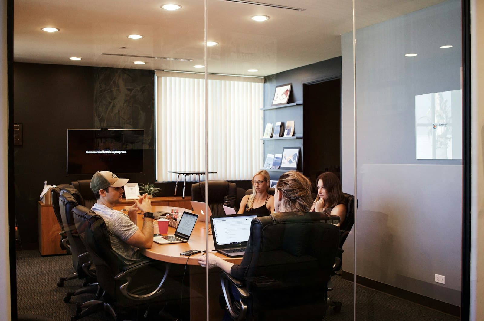 Agency team meeting around laptops in a conference room