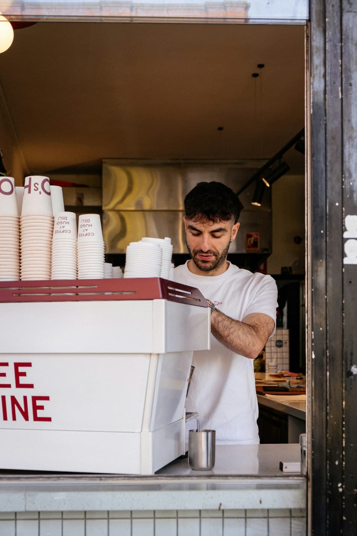 Barista preparing coffee behind the counter of a busy cafe