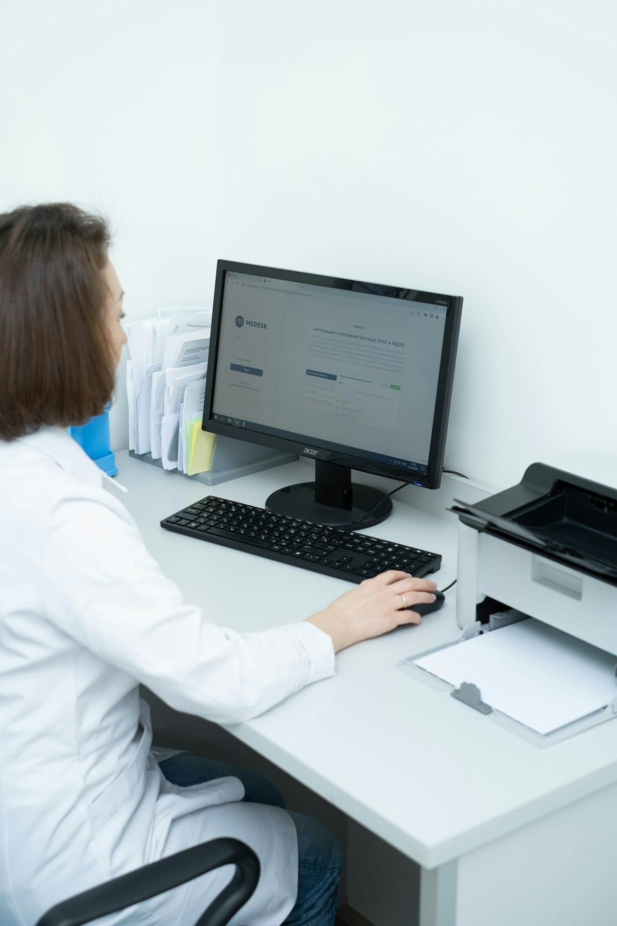 Healthcare worker reviewing documents at a desk in a bright office setting