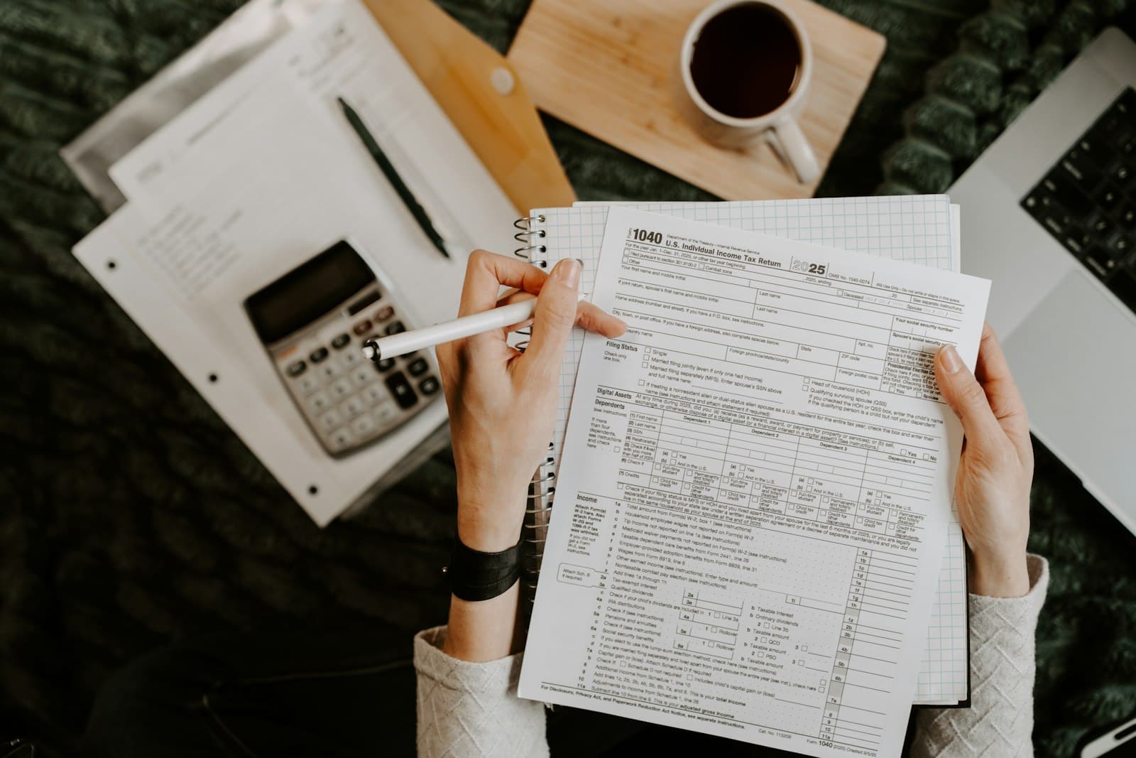 Tax documents, calculator and laptop on an accounting desk