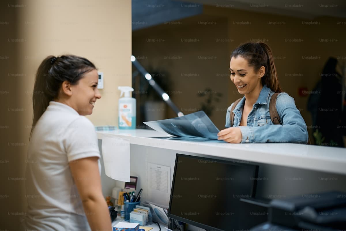 Patient reviewing documents at a physiotherapy clinic reception desk